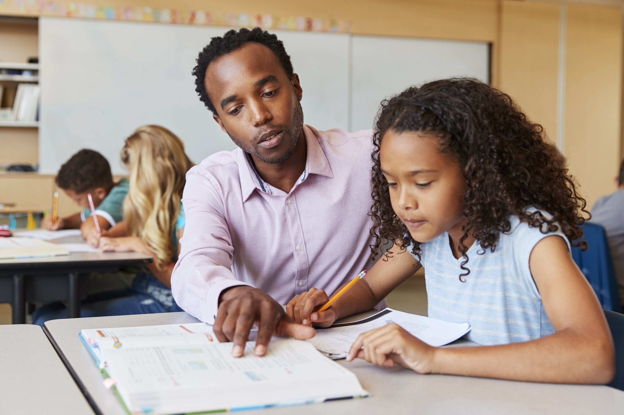 Teacher with student at desk-min Teacher with student at desk-min